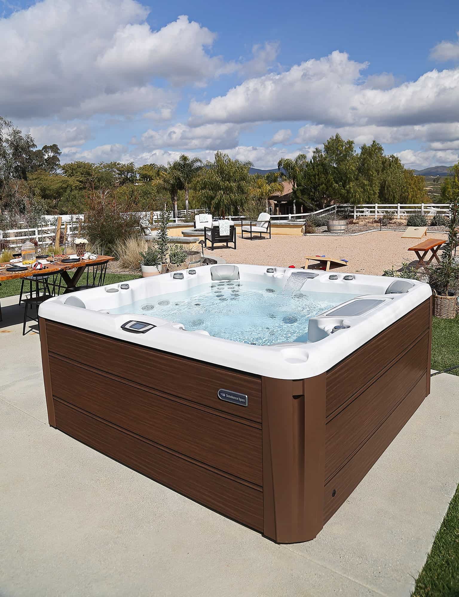 Sundance Spas hot tub installed into a rustic backyard living space