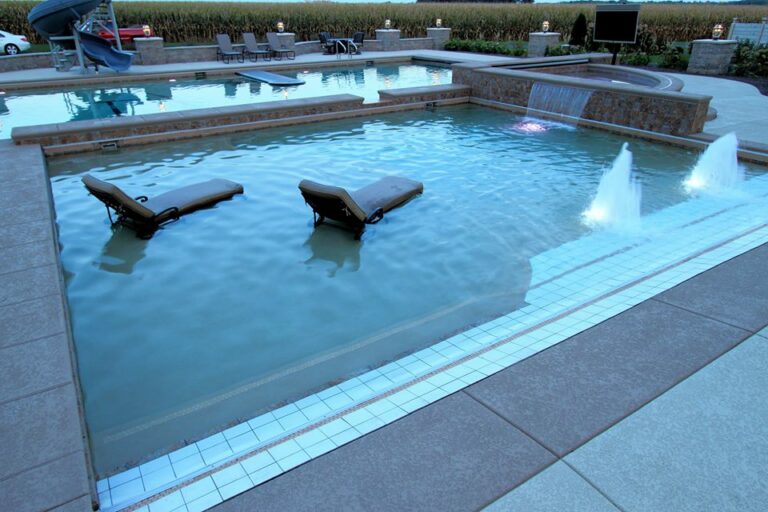 pool installation with lounge chairs waterfalls and LED lights