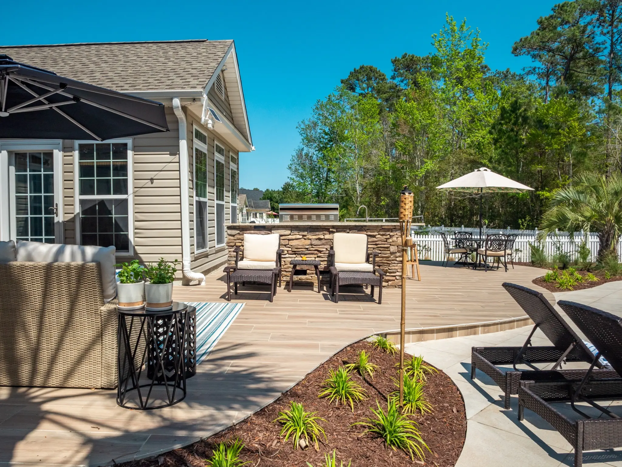 Poolside lounge, dining, and outdoor kitchen arranged on a coordinated patio