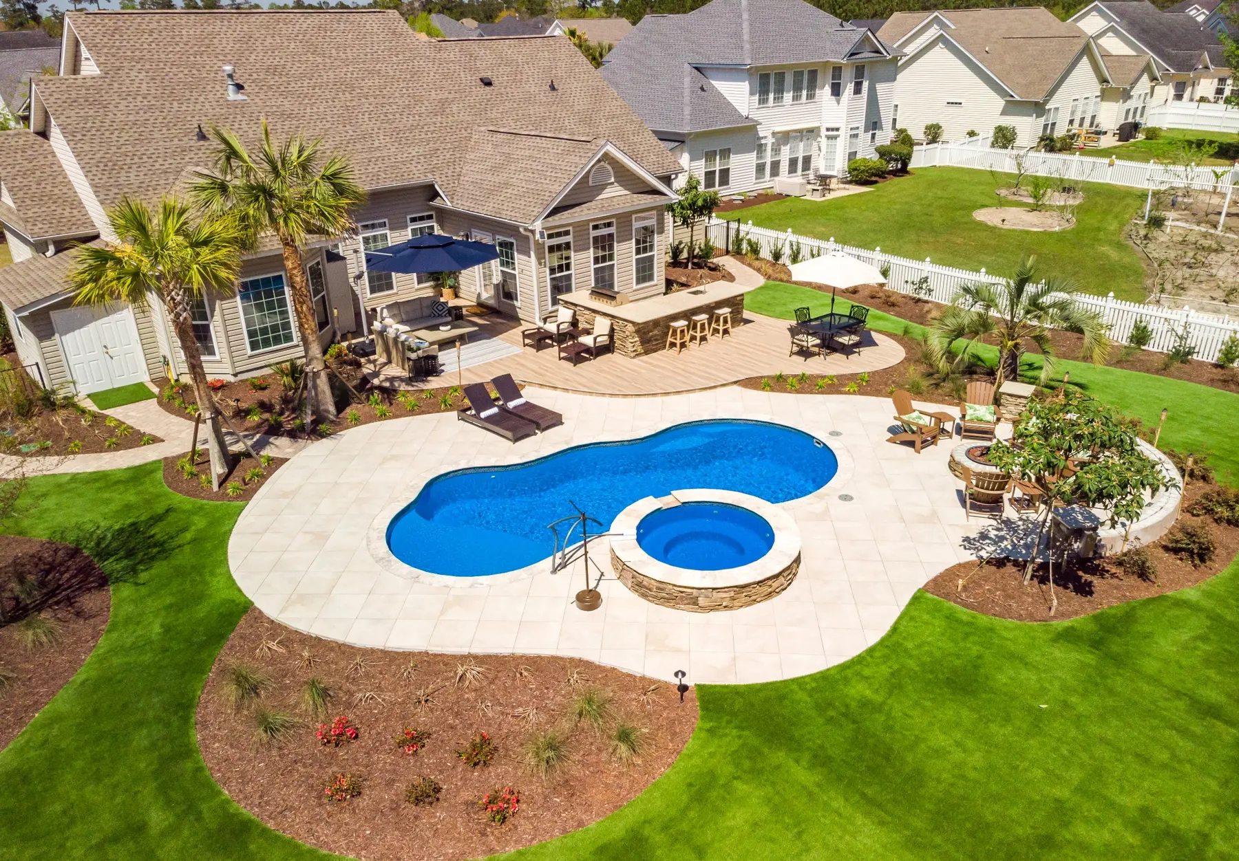 Outdoor kitchen and lounge area with poolside planting