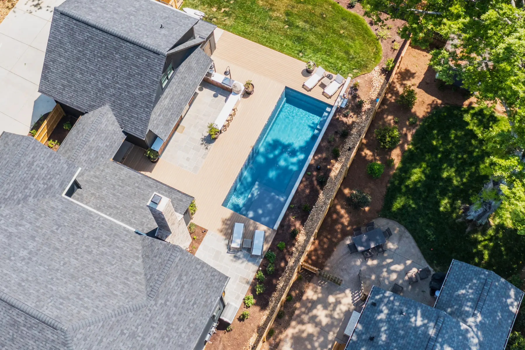 Aerial view of a pool, deck and landscaped backyard