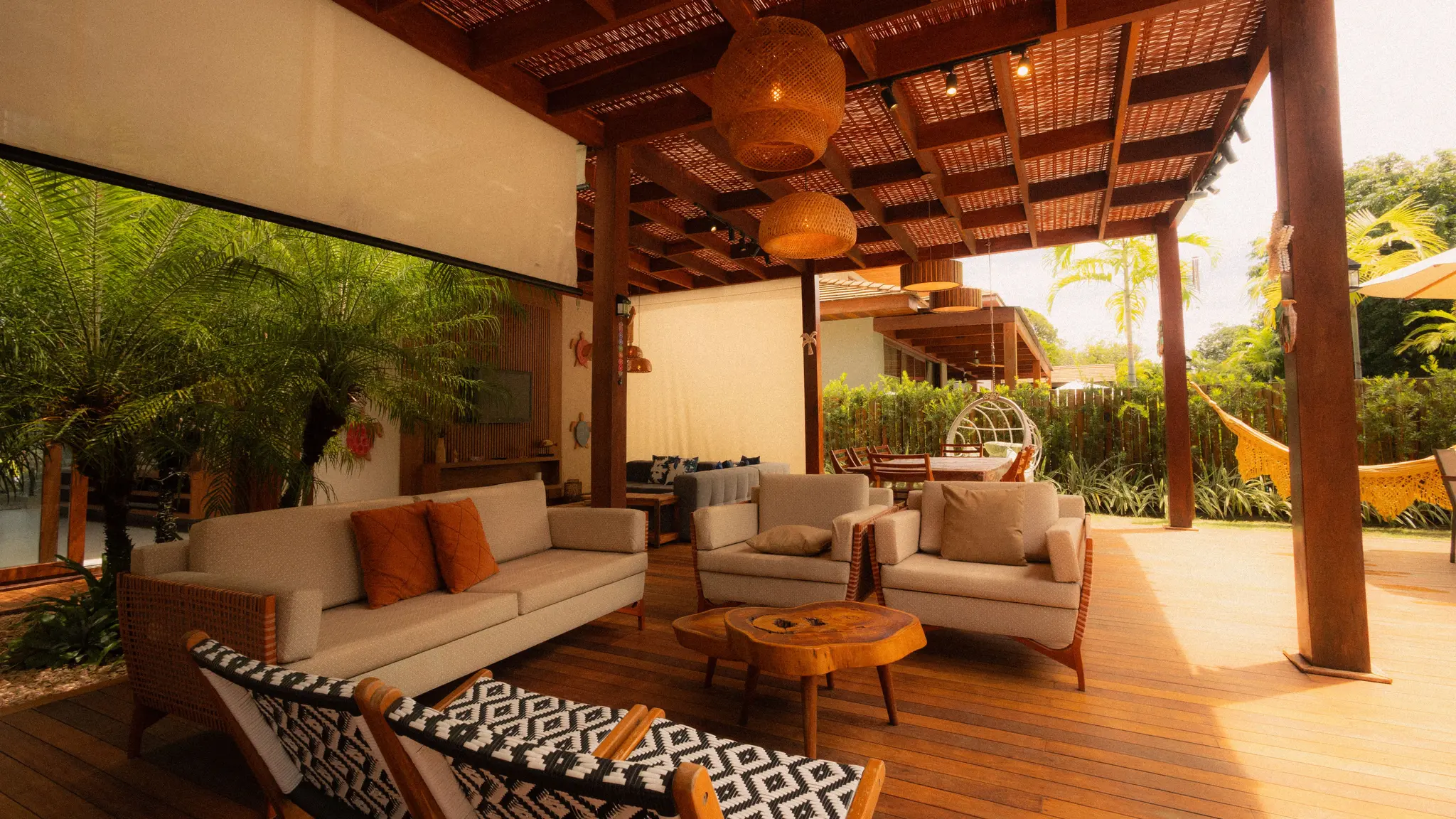 Covered wood pergola with woven ceiling, lounge furniture, lighting, and privacy screen